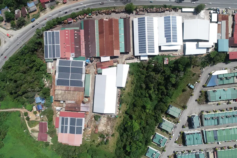Aerial view of rooftop solar on a timber sawmill with stacked timber (view 1)