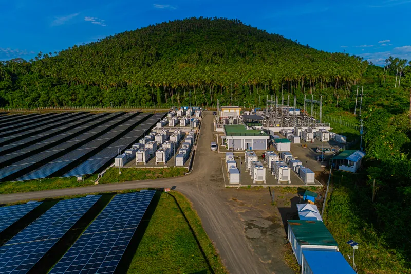 Containerised battery and power conversion units beside a solar array
